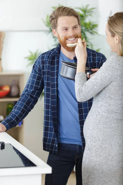 Gravid Kvinna Matlagning Och Erbjuda Husbance Sås Att Smaka — Stockfoto