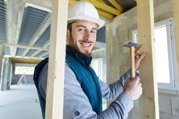 Happy Builder Hammers Nail Wooden Beam — Stock Photo, Image