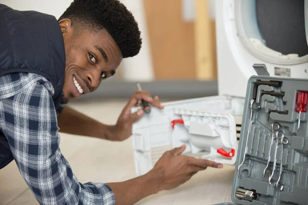 happy plumber with clipboard near washing machine