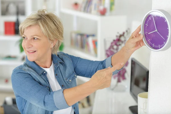 Senior Kvinna Håller Väggklocka Inomhus — Stockfoto