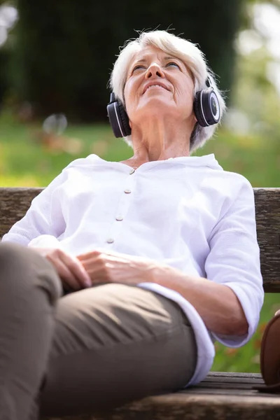 Donna Anziana Che Ascolta Musica Mentre Rilassa Nel Parco — Foto Stock