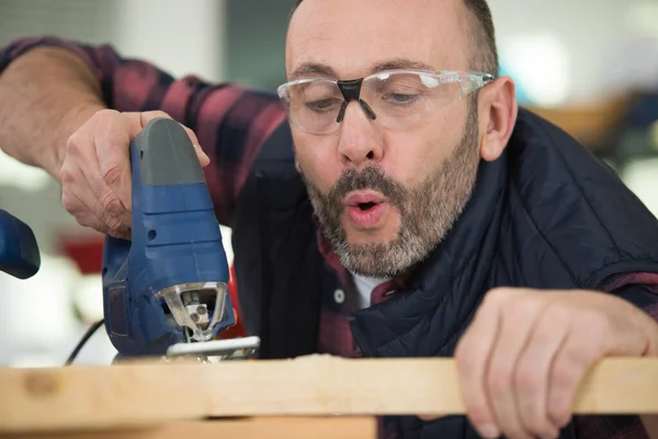 Mann Pustet Mit Stichsäge Sägemehl Aus Holz — Stockfoto