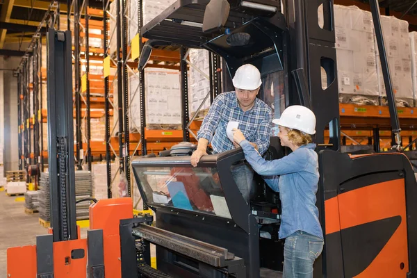 Kadın Depodaki Forklift Sürücüsüne Veriyor — Stok fotoğraf