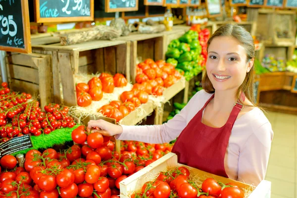 Verkäuferin mit einer Kiste Tomaten — Stockfoto