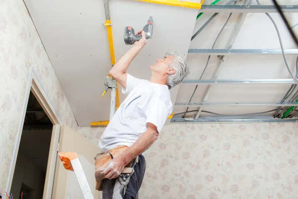 Builder putting up a suspended ceiling — Stock Photo, Image