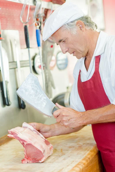 Carnicero picando un poco de cerdo — Foto de Stock