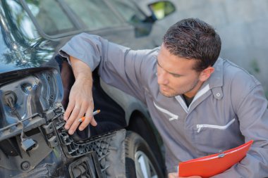 Mechanic taking notes of a car's faults clipart