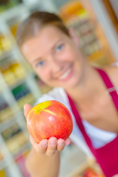 Trabalhador da loja segurando uma maçã — Fotografia de Stock