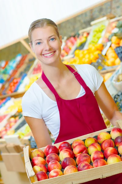 Femme tenant une caisse de fruits — Photo