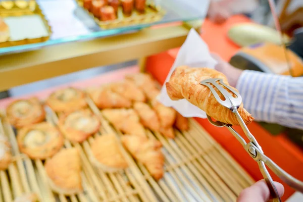 Croissant sostenido en pinzas — Foto de Stock