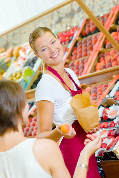 Asistente de tienda en el pasillo de la fruta — Foto de Stock