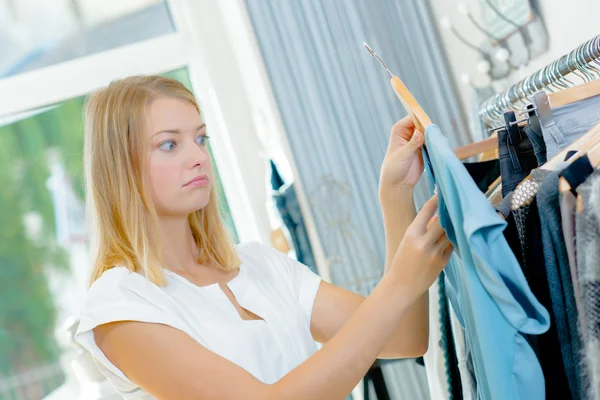 Vrouw browsen van het gangpad kleding — Stockfoto