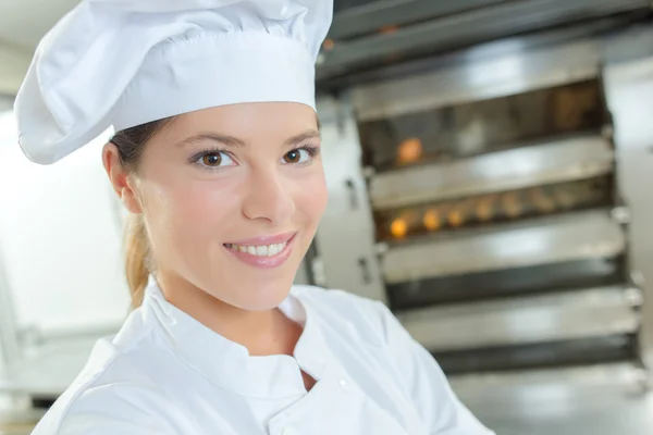 Female baker stood by bread oven — Stock Photo, Image