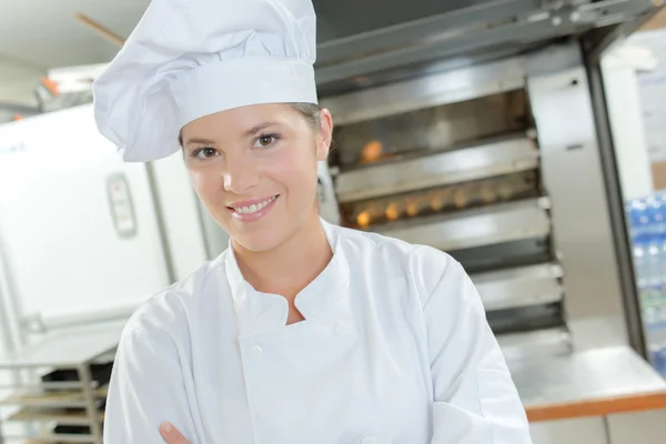 Female baker stood by bread oven — Stock Photo, Image