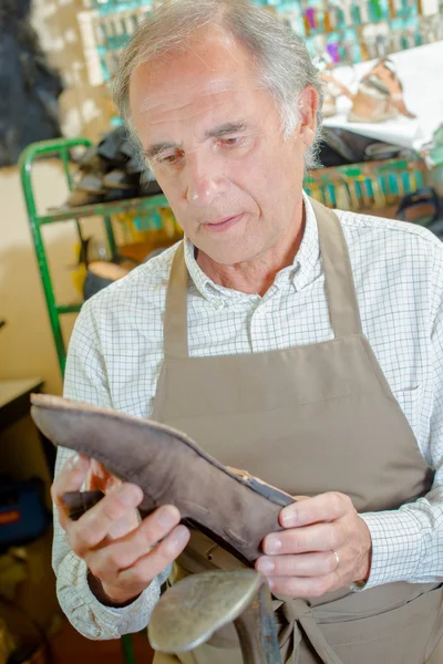 Schuster hält Schuh — Stockfoto