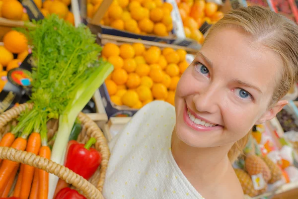 Mujer mostrando cesta de verduras Imagen De Stock