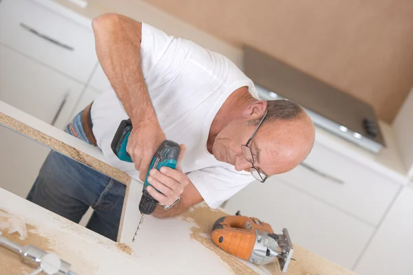 Tischler bohrt in eine Holzoberfläche — Stockfoto