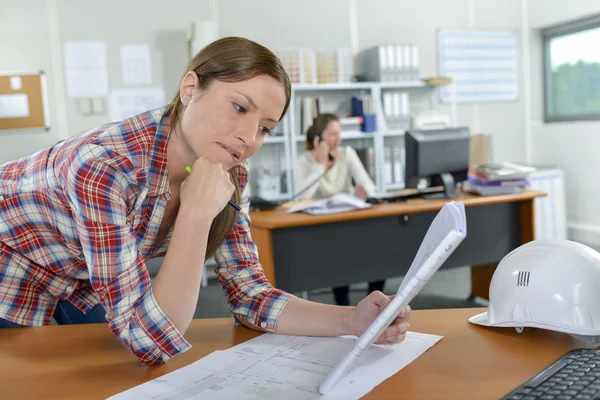 Frau schaut sich Pläne an — Stockfoto