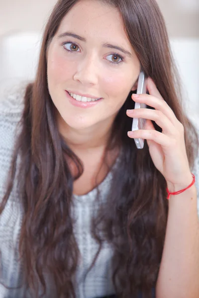 Frau benutzte ihr Handy während sie auf einem Sofa saß — Stockfoto