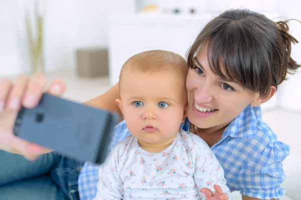 Bebeğini kendi kendine bir fotoğraf çekici kadın — Stok fotoğraf