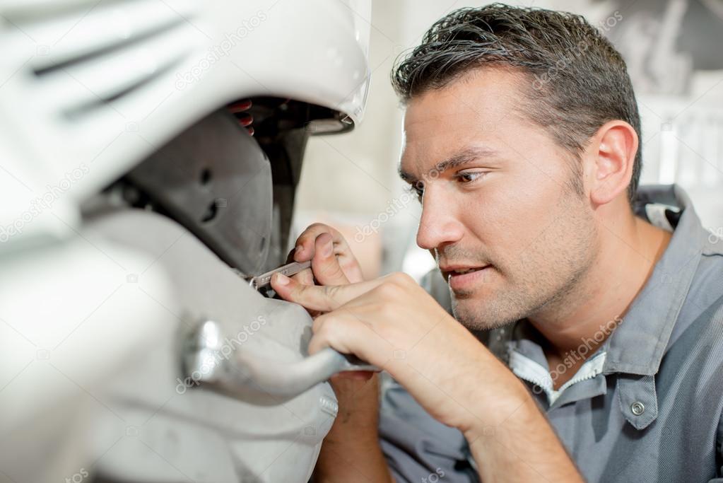 Mechanic examining a scooter Stock Photo by ©photography33 71476983