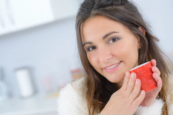 Kvinna som dricker kaffe i hennes kök — Stockfoto