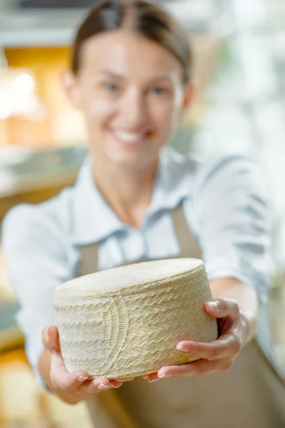Shop assistant holding cheese — Stock Photo, Image