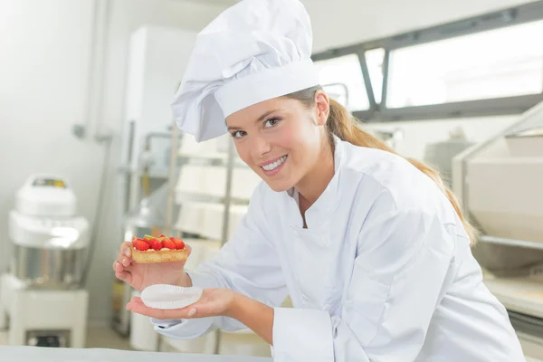 Baker holding one of her creations — Stock Photo, Image