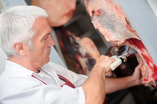 Açougueiro cortando carne — Fotografia de Stock