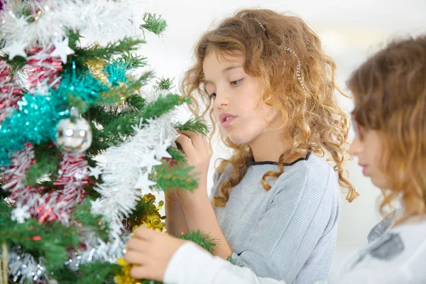 Dos hermanas decorando un árbol de Navidad — Foto de Stock