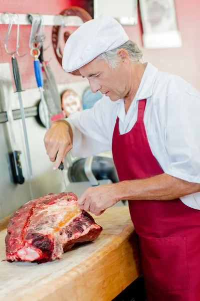 Slaktaren arbetar på en stor klippa av nötkött — Stockfoto
