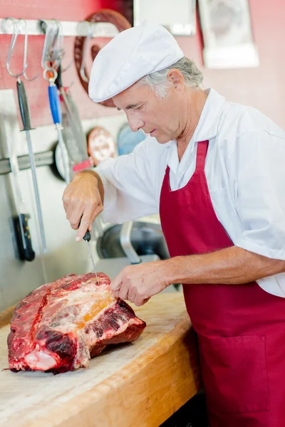 Carnicero trabajando en un gran corte de carne de res —  Fotos de Stock