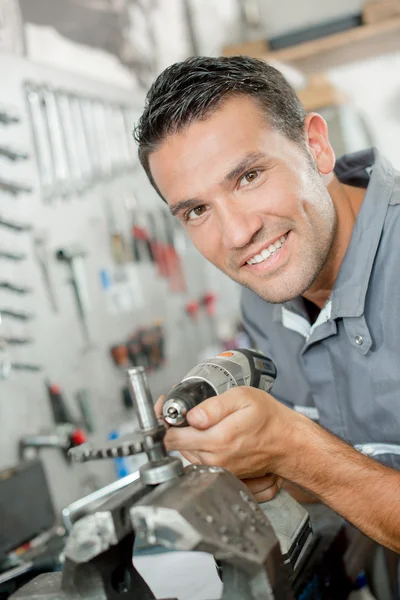 Mechanic using a drill to adjust part — Stock Photo, Image