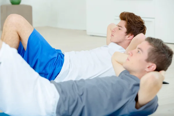 Twee mannen doen sit-ups — Stockfoto