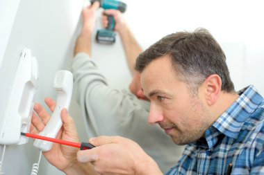 Man repairing an intercom phone clipart