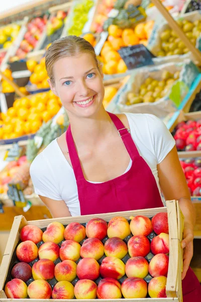 Femme tenant une caisse de fruits — Photo