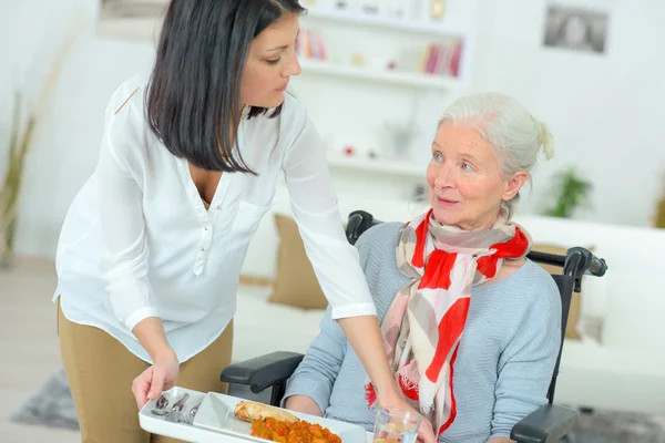 Serving disabled woman her meal — Stock Photo, Image