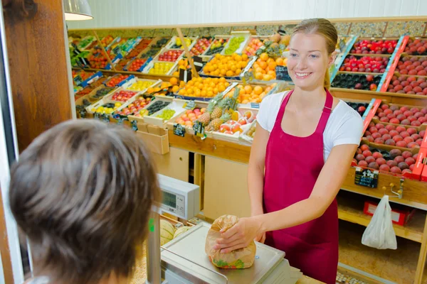 Assistante de magasin pesant les fruits — Photo