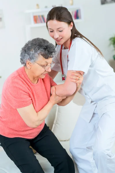 Docteur aidant une vieille dame à se tenir debout — Photo