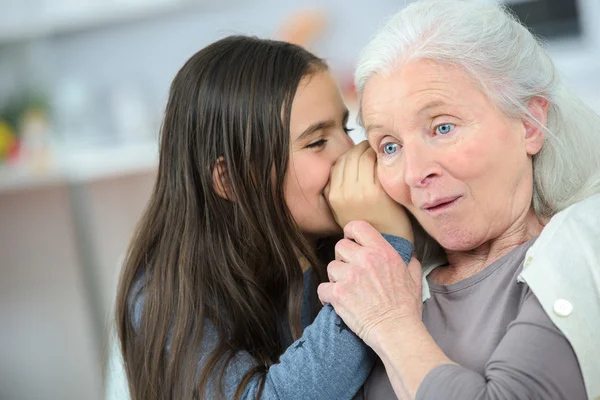 Liten flicka och mormor viskar hemligheter — Stockfoto