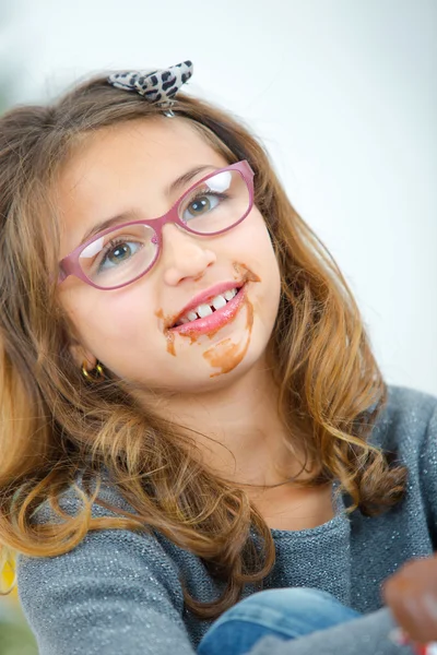 Menina com chocolate em torno de sua boca — Fotografia de Stock