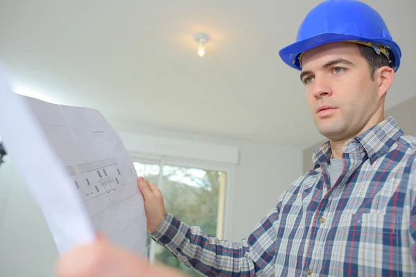 Construtor verificando os planos de chão — Fotografia de Stock
