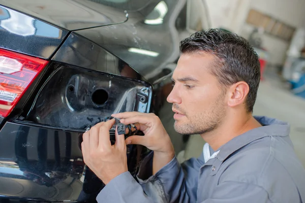 Mechaniker untersucht Kabel für Auto-Blinker — Stockfoto