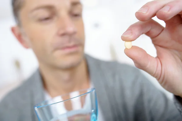 Mann nimmt Tablette mit einem Glas Wasser — Stockfoto