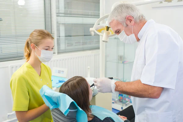 Ocupado dentista con un paciente — Foto de Stock