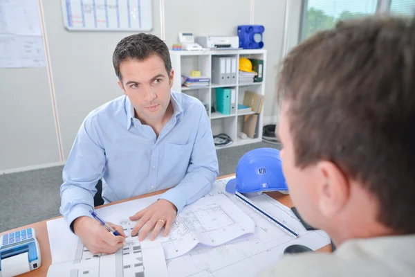 Architect running through plans with client — Stock Photo, Image