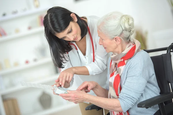 Spreken van oude dame door haar medicatie — Stockfoto