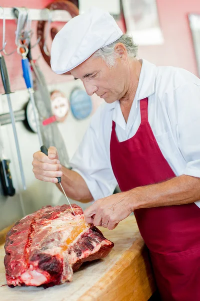 Skilled butcher preparing cuts of beef — Stock Photo, Image