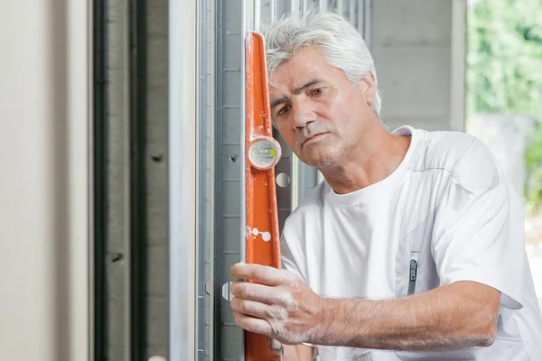 Maurer mit orangefarbener Wasserwaage — Stockfoto