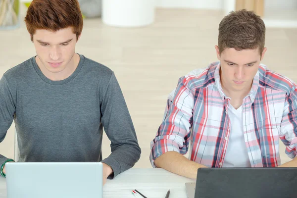 Dos estudiantes masculinos usando computadoras portátiles — Foto de Stock